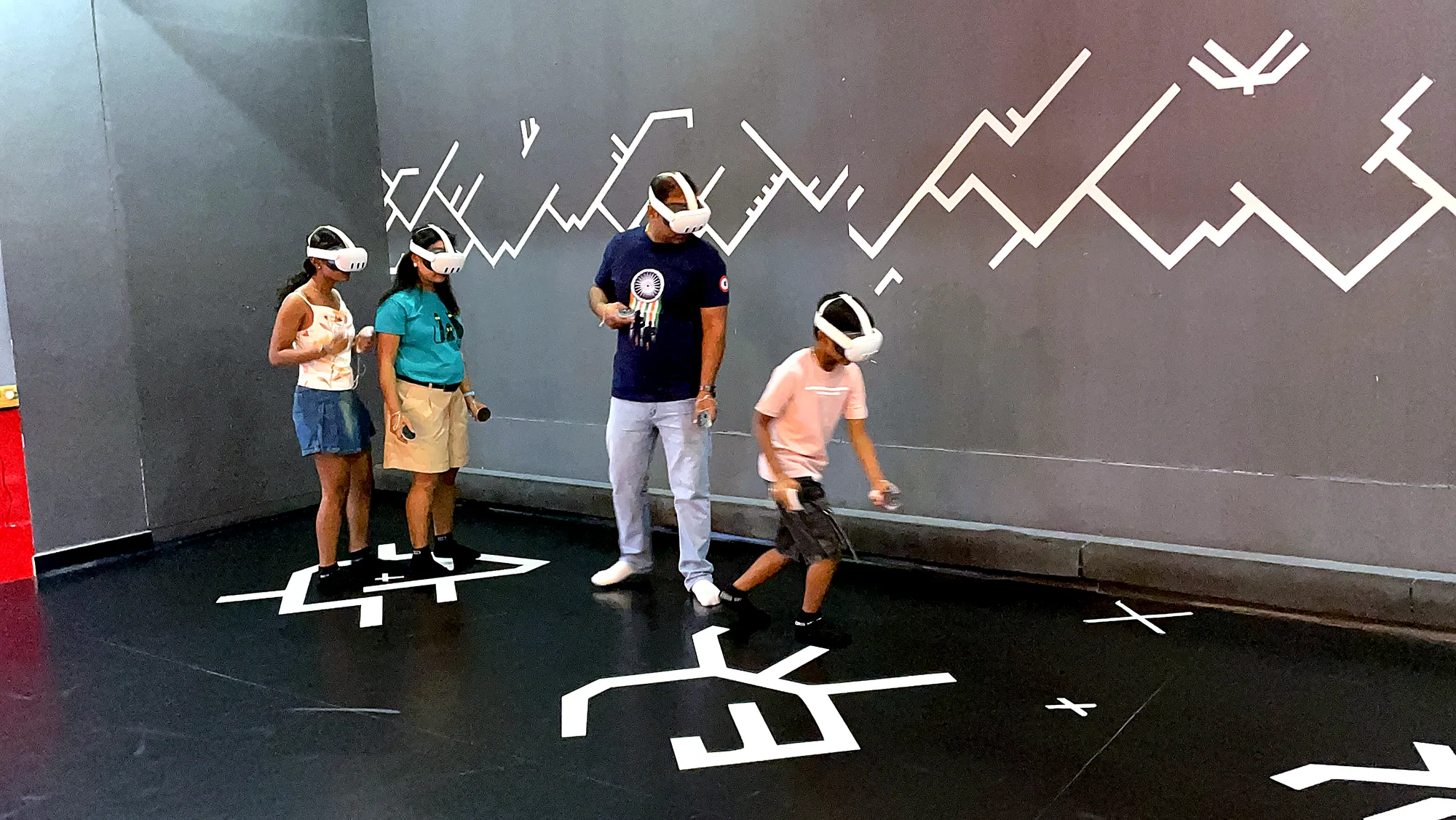 A family of four playing free-roam VR together at Totem, Koramangala