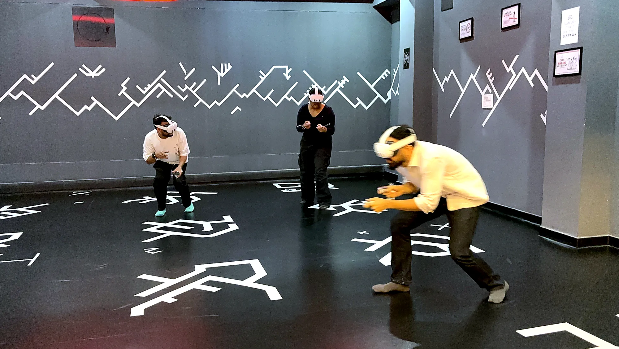 A group of friends mid-action during a free-roam VR session at Totem, Koramangala